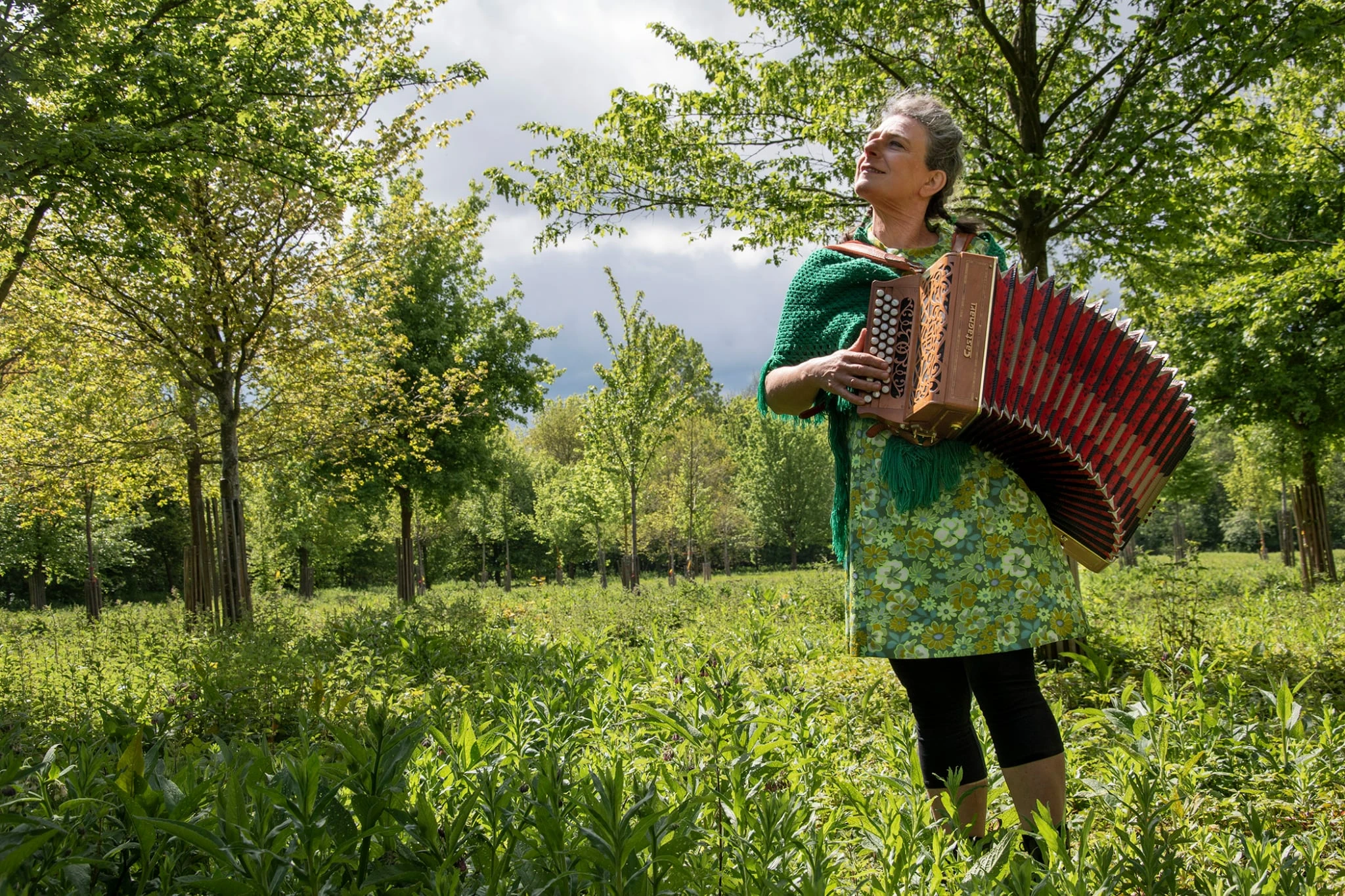 Laure Chailloux joue de l’accordéon au milieu des arbres